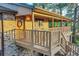 Exterior view of covered home deck with wooden railing and stairs, a warm wooden door, and brick accents at 9416 Mcshane Ct, Parker, CO 80134