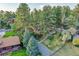 An aerial view showing a home surrounded by towering trees, with a vast green yard and a serene, natural setting at 9416 Mcshane Ct, Parker, CO 80134