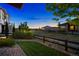 Serene backyard with lush lawn, a wooden fence, and mature trees under a twilight sky at 22978 E Bailey Cir, Aurora, CO 80016