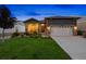 Well-maintained home with an attached garage, stone details, and a manicured lawn under the evening sky at 22978 E Bailey Cir, Aurora, CO 80016