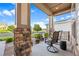 Relaxing front porch featuring stone pillars, comfortable seating, and a view of the well-maintained neighborhood at 22978 E Bailey Cir, Aurora, CO 80016