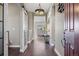 Elegant hallway with hardwood floors, stylish lighting, and a glimpse into the open living area at 22978 E Bailey Cir, Aurora, CO 80016