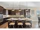 Spacious kitchen featuring dark cabinets, granite island, and stylish barstool seating, perfect for entertaining at 22978 E Bailey Cir, Aurora, CO 80016