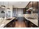 Modern kitchen showcasing dark wood cabinets, granite countertops, and stainless steel appliances, designed for functionality and style at 22978 E Bailey Cir, Aurora, CO 80016