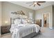Comfortable bedroom with ceiling fan, mountain art, and sunlit view into the primary bathroom at 22978 E Bailey Cir, Aurora, CO 80016