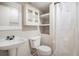 Bathroom featuring a sink, toilet, shelving, and shower with a white curtain at 8401 Sandreed Cir, Parker, CO 80134