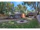 Large backyard showcasing a fire pit, seating area, lush green lawn, and brick structure at 1269 Krameria St, Denver, CO 80220