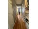 Hallway with hardwood floors and shelving, leading to the rooms in the home at 11502 E 7Th E Ave, Aurora, CO 80010