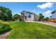 Expansive backyard showcasing lush green grass, mature trees, and a charming pergola-covered patio at 16863 Trail View Cir, Parker, CO 80134