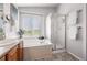 Bright bathroom featuring a soaking tub, glass-enclosed shower, and large window offering natural light at 16863 Trail View Cir, Parker, CO 80134