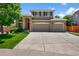 Inviting two-story home featuring a brick facade, arched entryway, and a spacious two-car garage at 16863 Trail View Cir, Parker, CO 80134