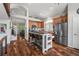 Modern kitchen with stainless steel appliances, island with bar seating, and sleek wood flooring at 16863 Trail View Cir, Parker, CO 80134