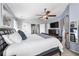 Bright and airy main bedroom with a ceiling fan, plush bedding, and ensuite bathroom at 16863 Trail View Cir, Parker, CO 80134