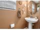 Stylish powder room featuring a pedestal sink and decorative mirror at 16863 Trail View Cir, Parker, CO 80134