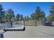 Backyard deck featuring a hot tub, outdoor dining area, and peaceful views of the surrounding trees at 6300 Summer Star Ln, Golden, CO 80403