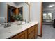 Bathroom features double sinks and vanity, accented with a plant, and has wood trim and doors at 6300 Summer Star Ln, Golden, CO 80403