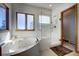 Bathroom featuring a tub, glass enclosed shower, and a window with natural light at 6300 Summer Star Ln, Golden, CO 80403