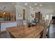 Bright dining room featuring a modern light fixture, stone fireplace, and a solid wood dining table at 6300 Summer Star Ln, Golden, CO 80403
