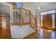 Bright, inviting home foyer featuring hardwood floors, wooden staircase, and a beautiful wooden front door at 6300 Summer Star Ln, Golden, CO 80403