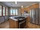 Kitchen with modern stainless steel appliances, wood cabinets, island cooktop, and scenic views at 6300 Summer Star Ln, Golden, CO 80403