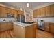 Kitchen island with gas cooktop and stainless steel appliances are framed by wooden cabinets and hardwood floors at 6300 Summer Star Ln, Golden, CO 80403