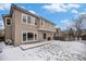 Back of home and yard with snow on a sunny day at 13486 Clayton St, Thornton, CO 80241