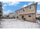 Exterior view of a home's backyard featuring a gas grill and snowy lawn at 13486 Clayton St, Thornton, CO 80241