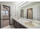 Bathroom with a double sink vanity, large mirror, and access to the bedroom at 13486 Clayton St, Thornton, CO 80241