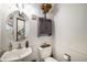 Cozy powder room with a decorative mirror, a charming wall cabinet and a white sink at 13486 Clayton St, Thornton, CO 80241