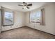 This cozy bedroom has neutral carpet, a ceiling fan and two windows overlooking the neighborhood at 13486 Clayton St, Thornton, CO 80241