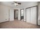 Bedroom featuring neutral carpet, ceiling fan, and access to a bathroom and closet at 13486 Clayton St, Thornton, CO 80241
