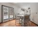 Dining room area featuring wood floors, a white round table, and a view of the snowy backyard through glass doors at 13486 Clayton St, Thornton, CO 80241