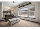 Bright living room with large windows overlooking a snow-covered backyard and a neutral-toned sofa at 13486 Clayton St, Thornton, CO 80241