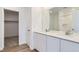Modern bathroom with dual sinks, white cabinetry, and a large mirror at 22036 E 39Th Pl, Aurora, CO 80019