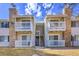 Stylish condo exterior features stone accents, white railings, and stairs leading to upper-level units at 14473 E Jewell Ave # 202, Aurora, CO 80012