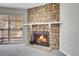 Close-up of a living room fireplace with a stone surround, a white mantel, and a view to balcony at 14473 E Jewell Ave # 202, Aurora, CO 80012