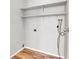 Bright laundry room with wood-look floors and shelving offers functionality and space for organizing household tasks at 14473 E Jewell Ave # 202, Aurora, CO 80012