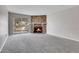 Inviting living room with stone fireplace, white mantel, gray carpet, and sliding glass doors to the balcony at 14473 E Jewell Ave # 202, Aurora, CO 80012