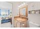 Bright bathroom with a wooden-framed mirror and cabinets, offering practical storage solutions at 8408 Everett Way # B, Arvada, CO 80005