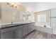 Modern bathroom featuring gray cabinets, granite countertops, and a tub with shower at 24676 E Florida Ave, Aurora, CO 80018