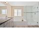 Bathroom featuring a tub, glass-enclosed shower, tile accents, and vanity with stone countertop at 24676 E Florida Ave, Aurora, CO 80018