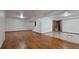 Finished basement with wood floors, neutral walls, ceiling lights, and access to other rooms at 2720 E 121St Pl, Thornton, CO 80241