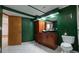 Unique bathroom features dark green walls, a white-tiled floor, a wood cabinet, and a modern vessel sink at 2720 E 121St Pl, Thornton, CO 80241