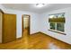 Bedroom featuring wood floors, a neutral color scheme, and a door to the ensuite bathroom at 2720 E 121St Pl, Thornton, CO 80241