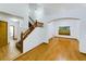 Bright foyer featuring hardwood floors, a staircase with wood railings, and an open floor plan at 2720 E 121St Pl, Thornton, CO 80241
