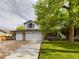 Charming two-story home boasts a three-car garage and a well-maintained front lawn with mature trees at 2720 E 121St Pl, Thornton, CO 80241