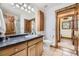 Well-lit bathroom features a single sink vanity, a toilet, and a doorway leading to another room at 538 Sawmill Creek Rd, Evergreen, CO 80439