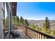 Outdoor deck with two chairs, overlooking the scenic mountain views and surrounding trees at 538 Sawmill Creek Rd, Evergreen, CO 80439