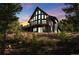 Exterior view of A-frame home at sunset, surrounded by trees at 538 Sawmill Creek Rd, Evergreen, CO 80439