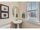 Powder room with pedestal sink, large mirror, and window at 9435 E 108Th Pl, Commerce City, CO 80640